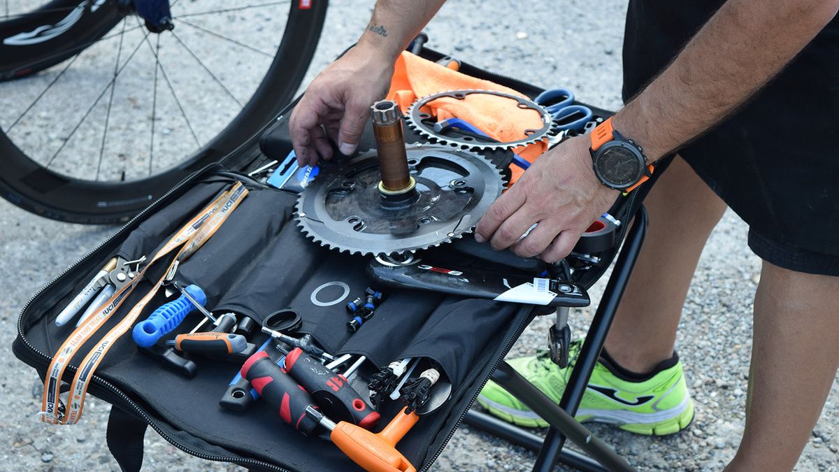 An Aqua Blue Sport mechanic changes chainrings ahead of the team time trial start