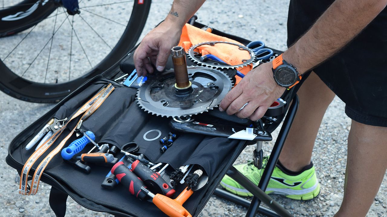 An Aqua Blue Sport mechanic changes chainrings ahead of the team time trial start
