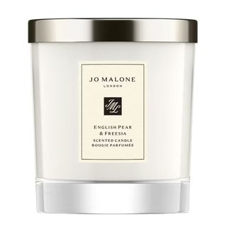 A classic, clear Jo Malone candle vase with a silver snuffer lid and Jo Malone label in cream