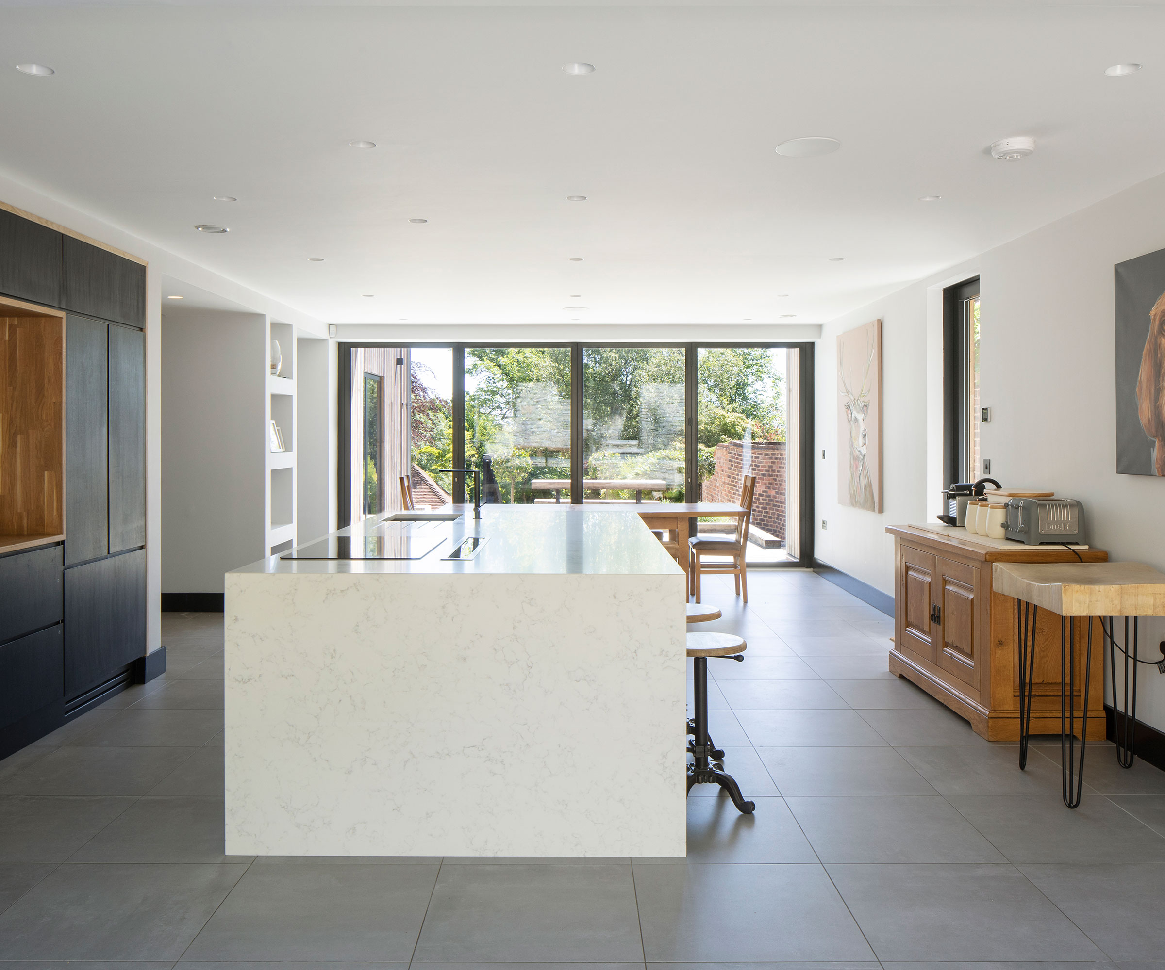 kitchen/dining space with bifold doors across the end wall of the room overlooking a private outdoor space
