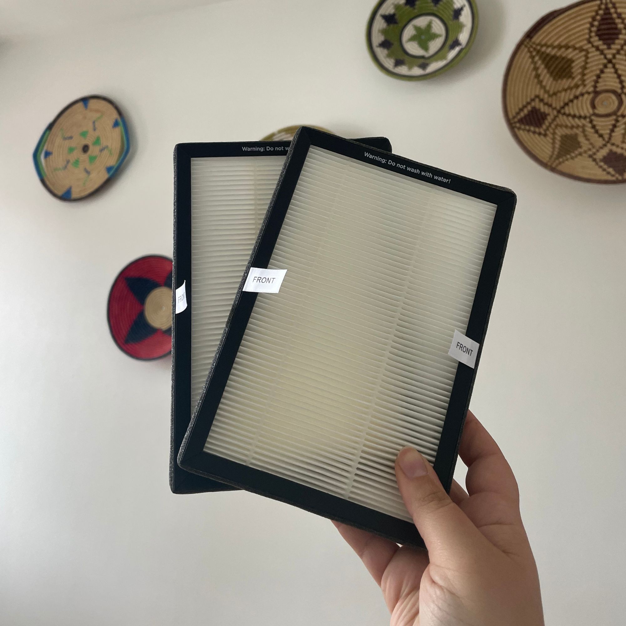 Hand holding up two filters for the Russell Hobbs RHBLDL12 Bladeless Tower Fan