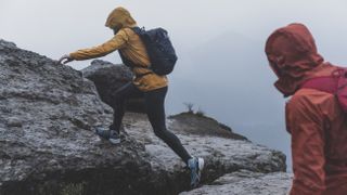 Two hikers on rocky terrain in bad weather