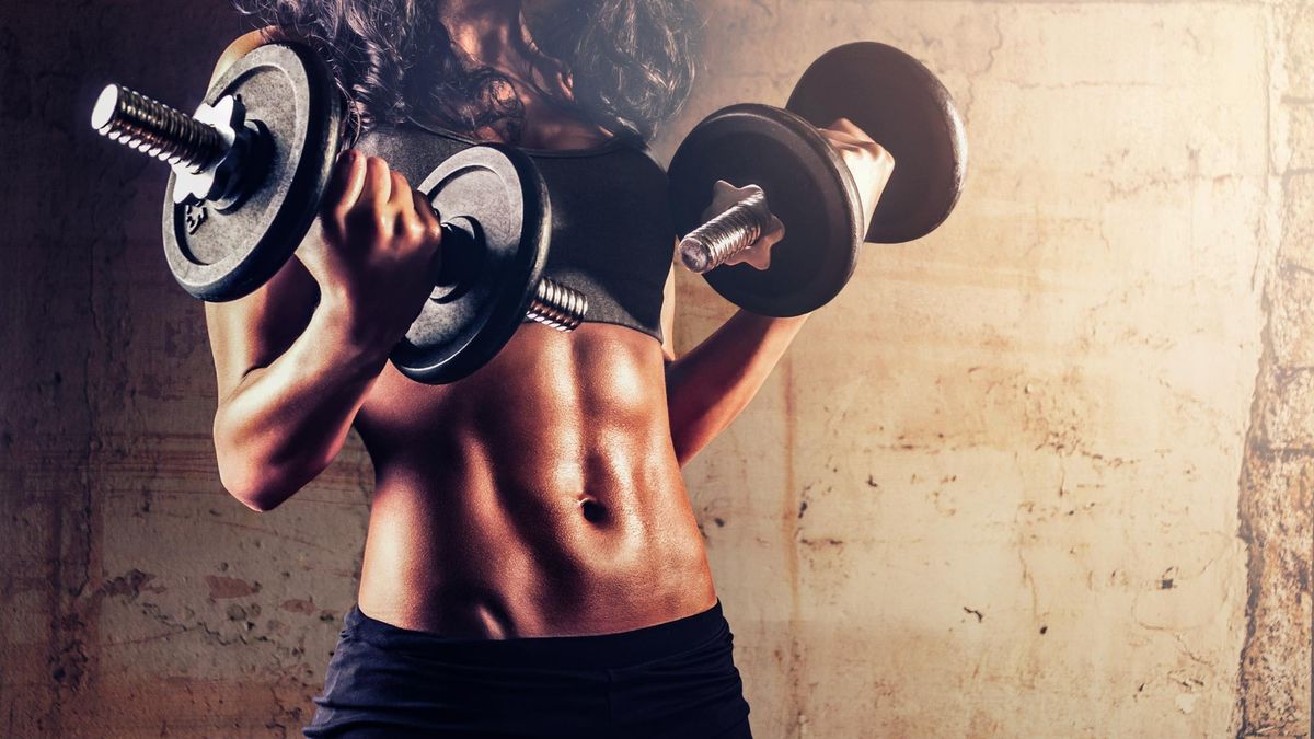 a woman carrying dumbbells in front of her stomach