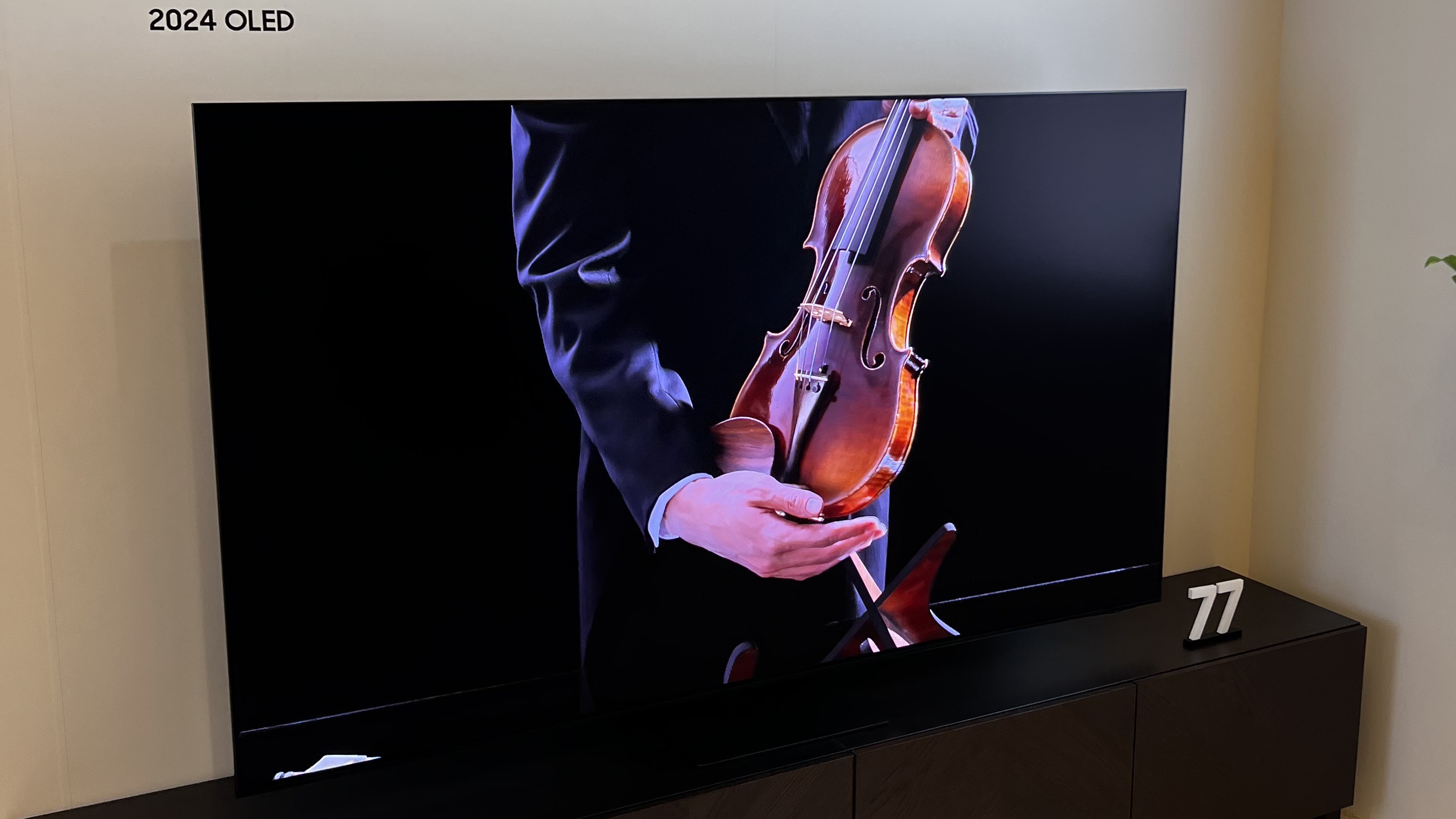 The Samsung S95D at CES 2024 displaying a person holding a violin.