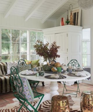 White dining room, green chairs, animal print rug