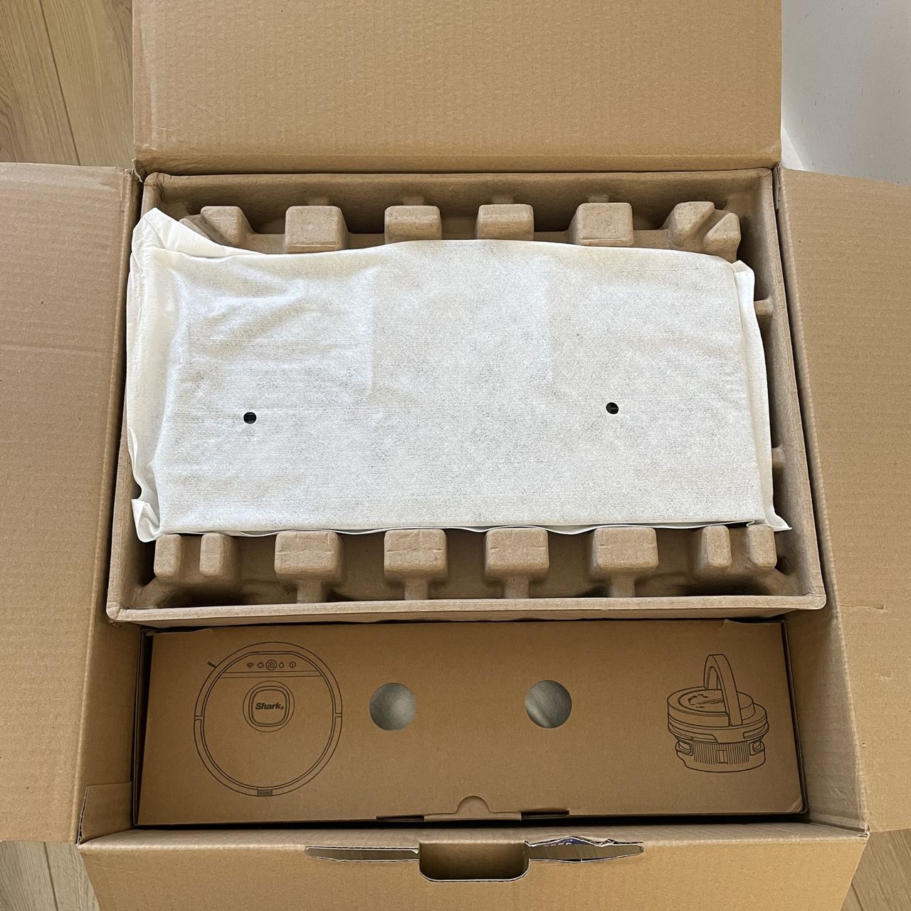 Inside of the Shark PowerDetect UV Reveal 2-in-1 Vac &amp; Mop Robot box, with everything encased in cardboard