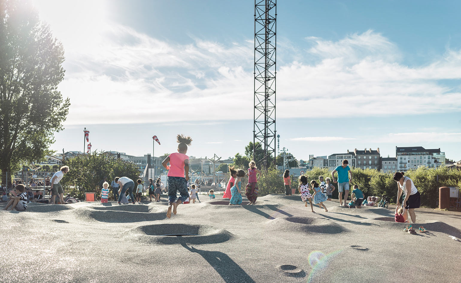 People playing on a soft silvery sphere with trampolines