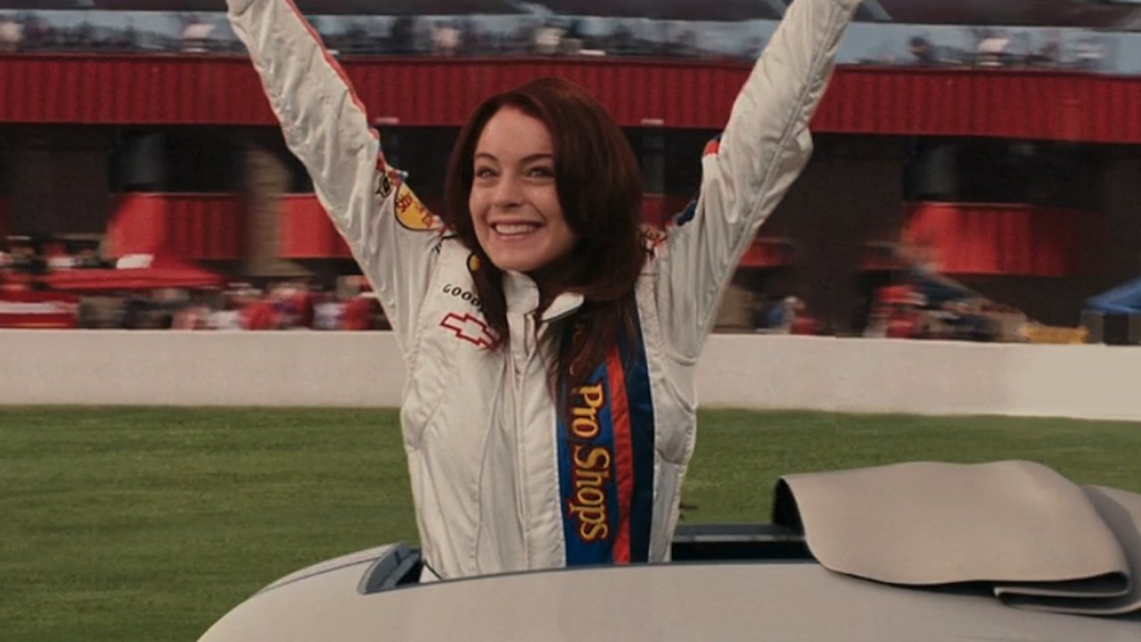 Lindsay Lohan smiling and raising her arms up on race track in Herbie: Fully Loaded