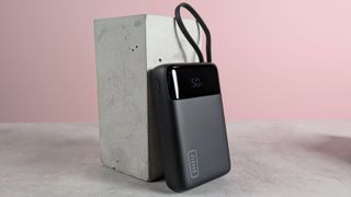 INIU P51L-E1 Power Bank leaning on plinth on desk with pink background