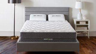 GhostBed discount codes, sales and deals: Image shows the GhostBed Luxe mattress with a white quilted top and grey base, placed on a light grey fabric bed