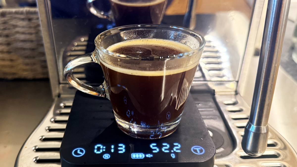 A photo of espresso made on the breville bambino plus espresso machine in a shot glass with the wacaco exagram pro scale