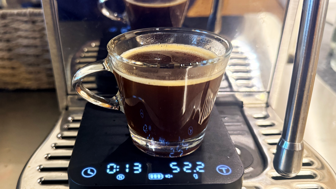 A photo of espresso made on the breville bambino plus espresso machine in a shot glass with the wacaco exagram pro scale
