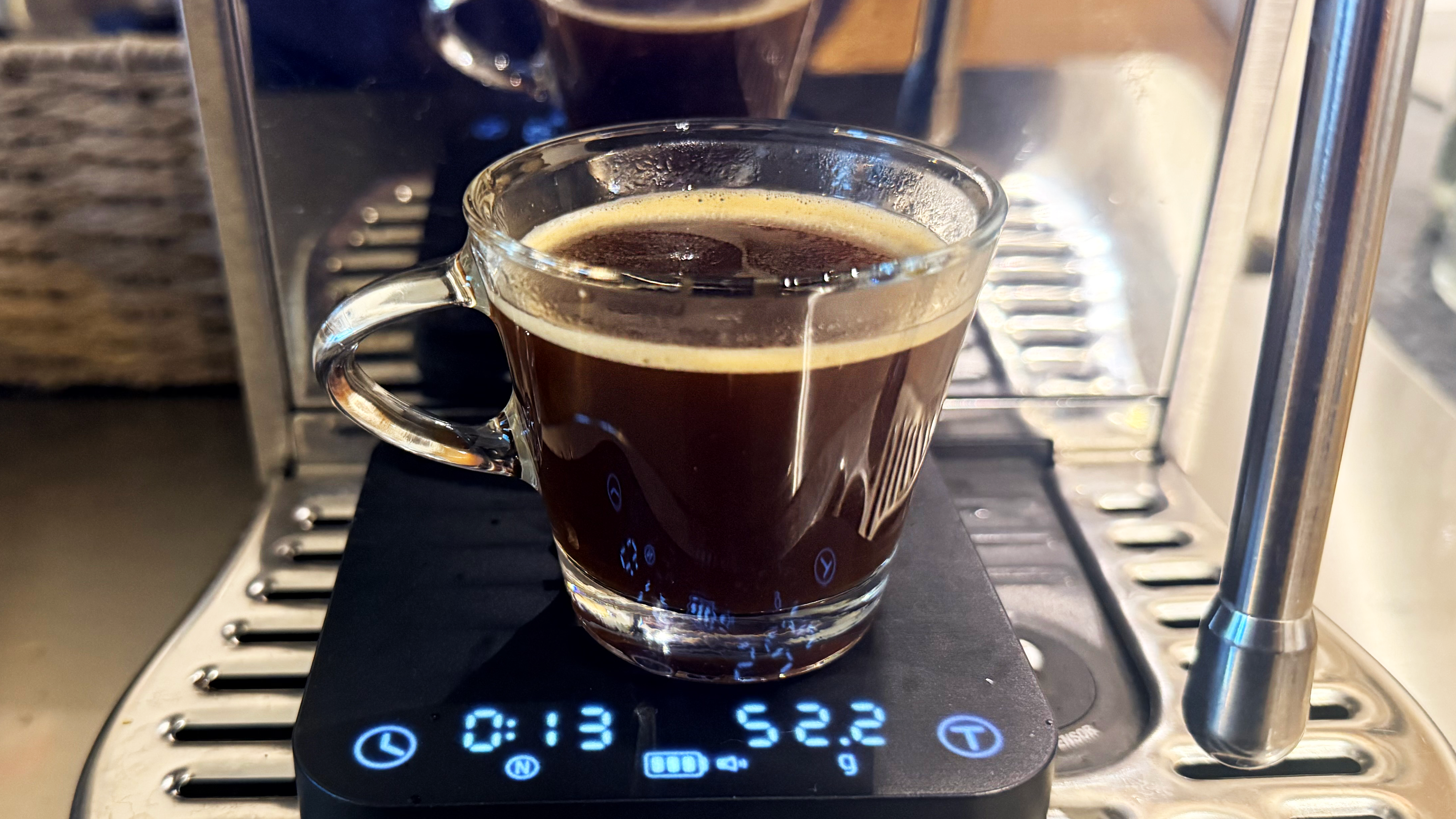 A photo of espresso made on the breville bambino plus espresso machine in a shot glass with the wacaco exagram pro scale