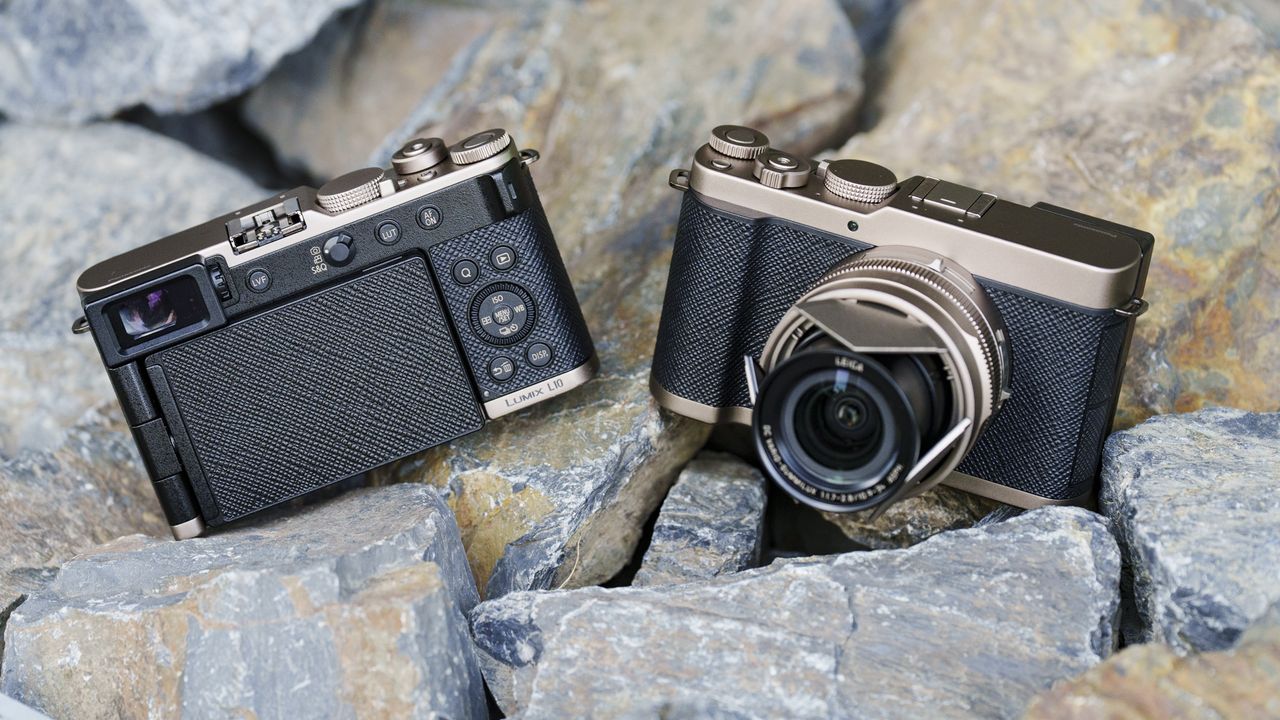 The Gold Titanium Special Edition of the Panasonic Lumix L10 compact camera, sat on gray and rust-colored rocks