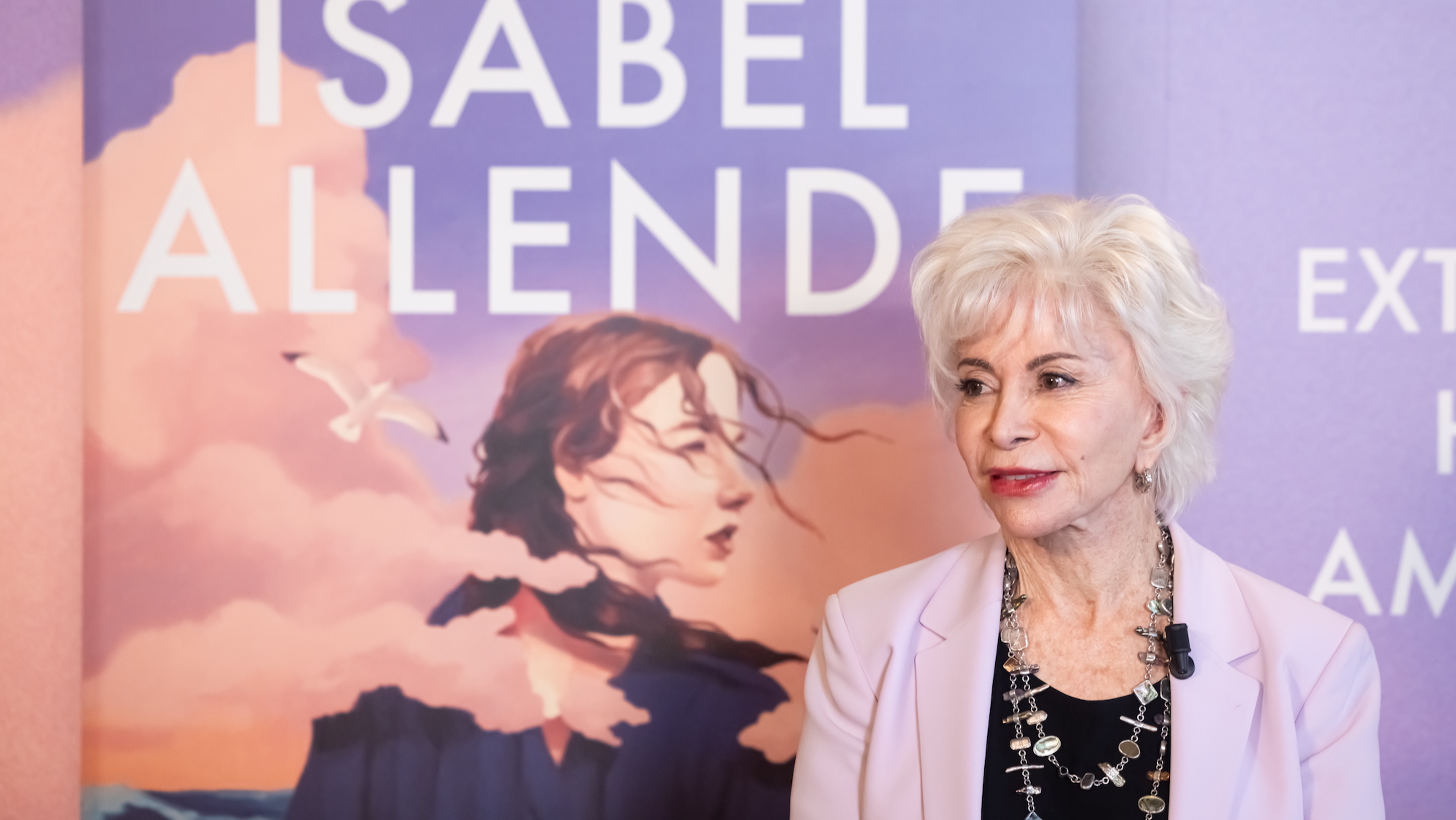 Isabel Allende stands in front of a poster of the cover of her new book 'My Name is Emilia del Valle'