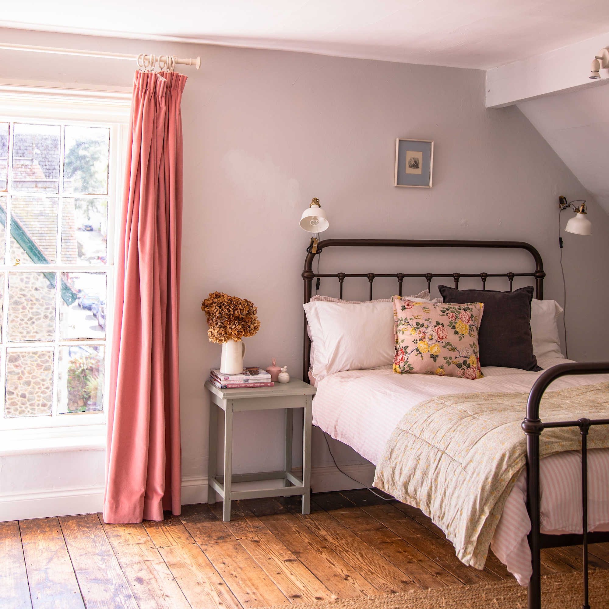 bedroom with white painted walls and metal double bed with quilt