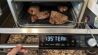 Cosori 26-Quart Ceramic Air Fryer Oven cooking steak with the thermometer