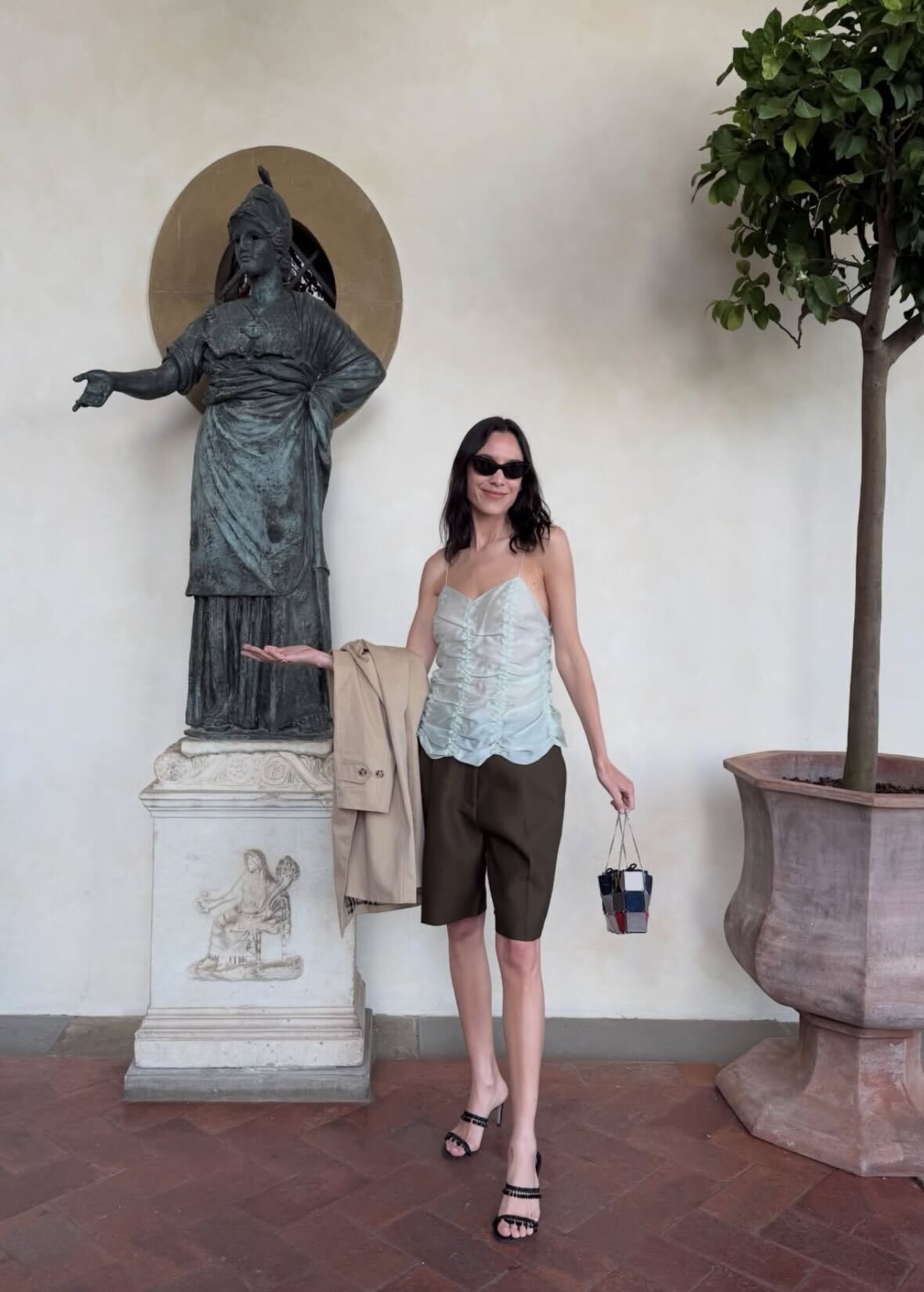 Alexa wears a ruched top, bermuda shorts, and heels.