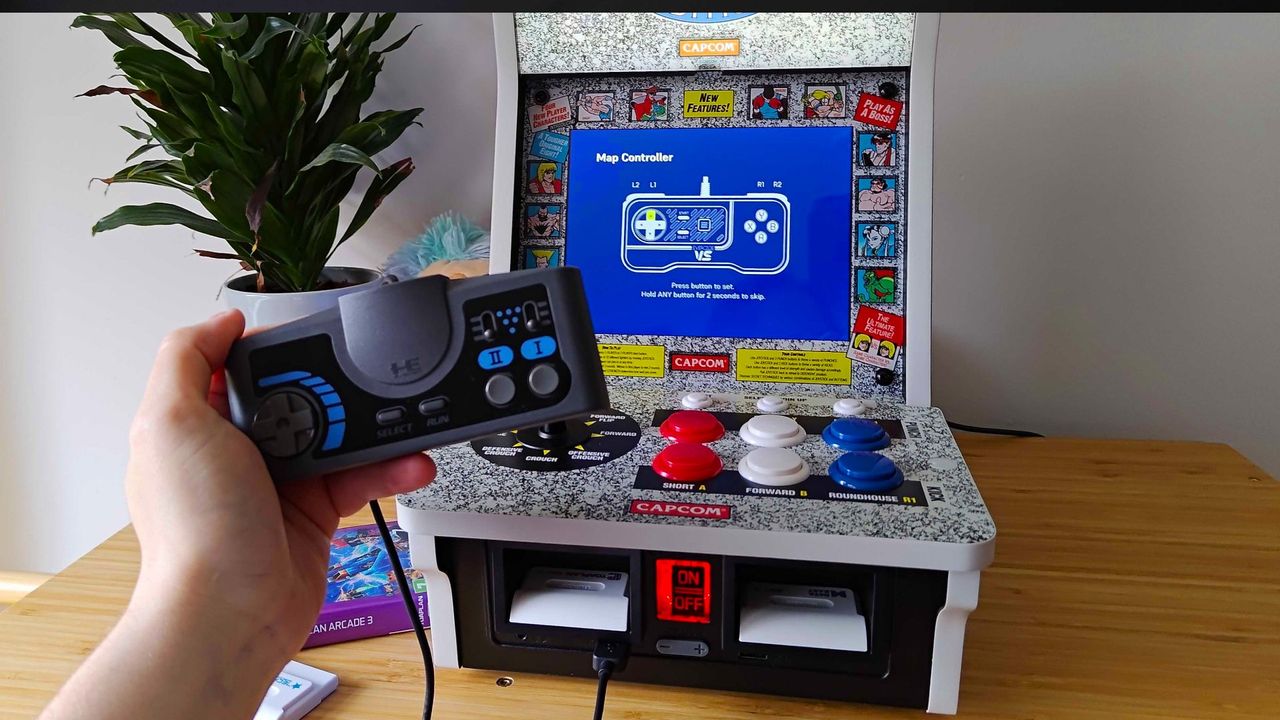 Evercade Alpha with hand holding PC Engine USB controller in front