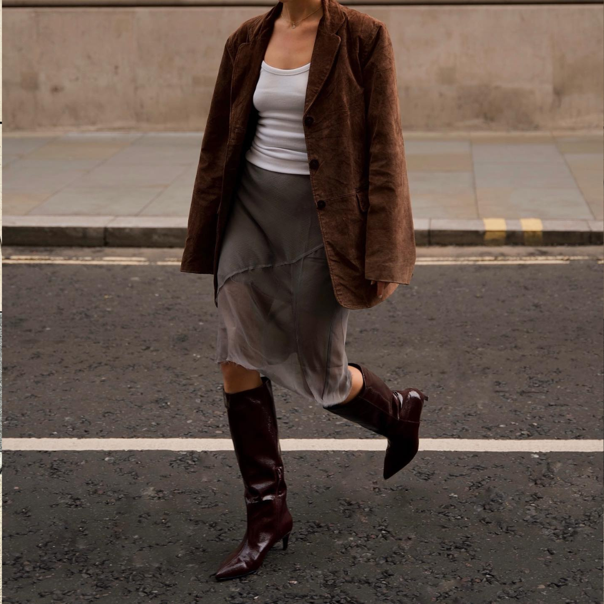 Chloe Kath Butler wearing a sheer skirt, suede jacket and pointed boots