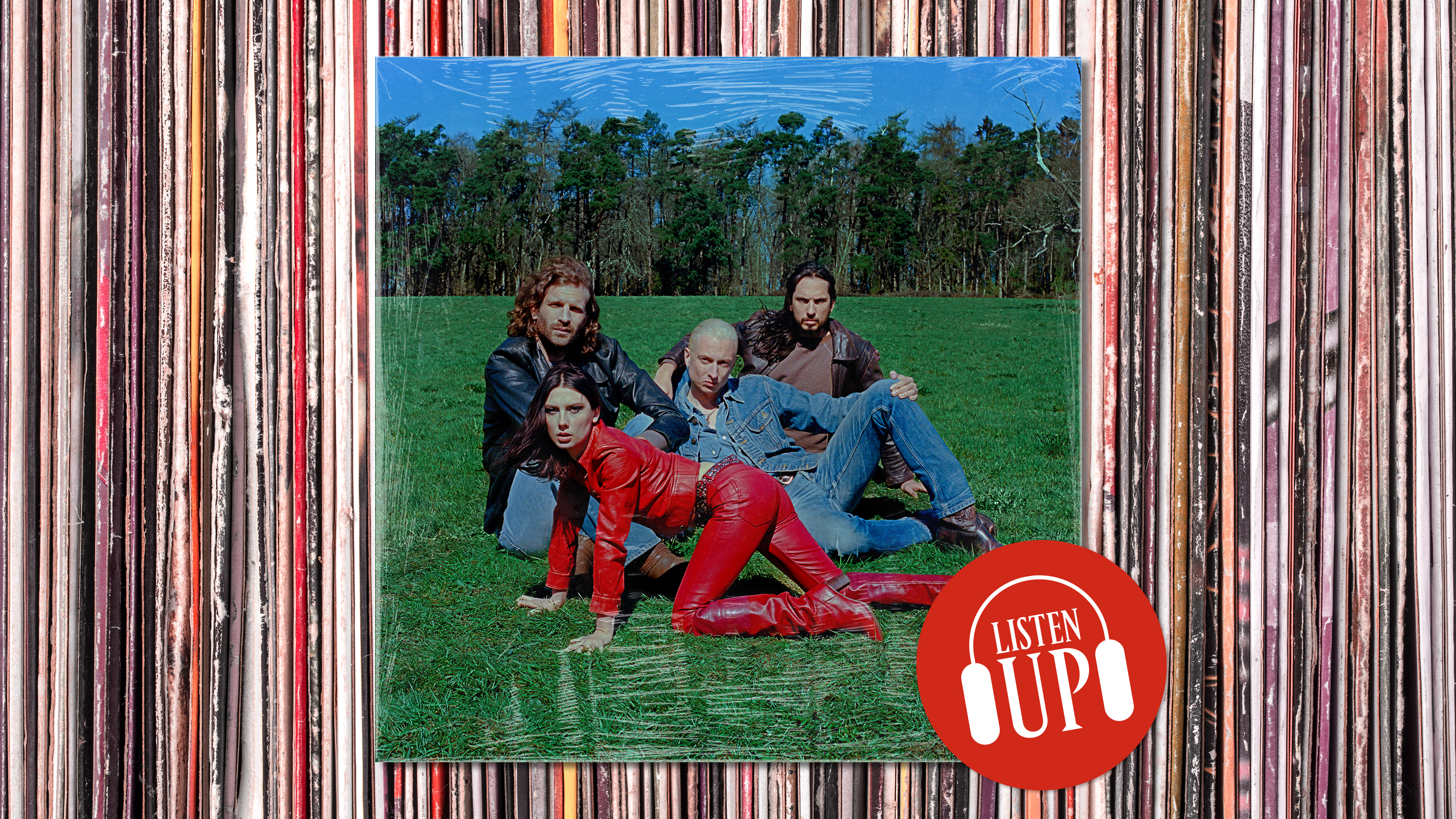 a posed shot of the band wolf alice sitting in a green field with front woman ellie rowsell wearing a red leather outfit and crawling on all fours with the treated marie cliare listen up franchise logo on top