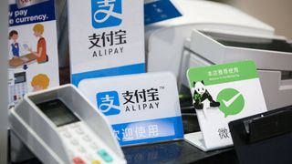 A payment terminal in China in front of a sign for AliPay