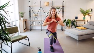 Woman performs lunge with a resistance band