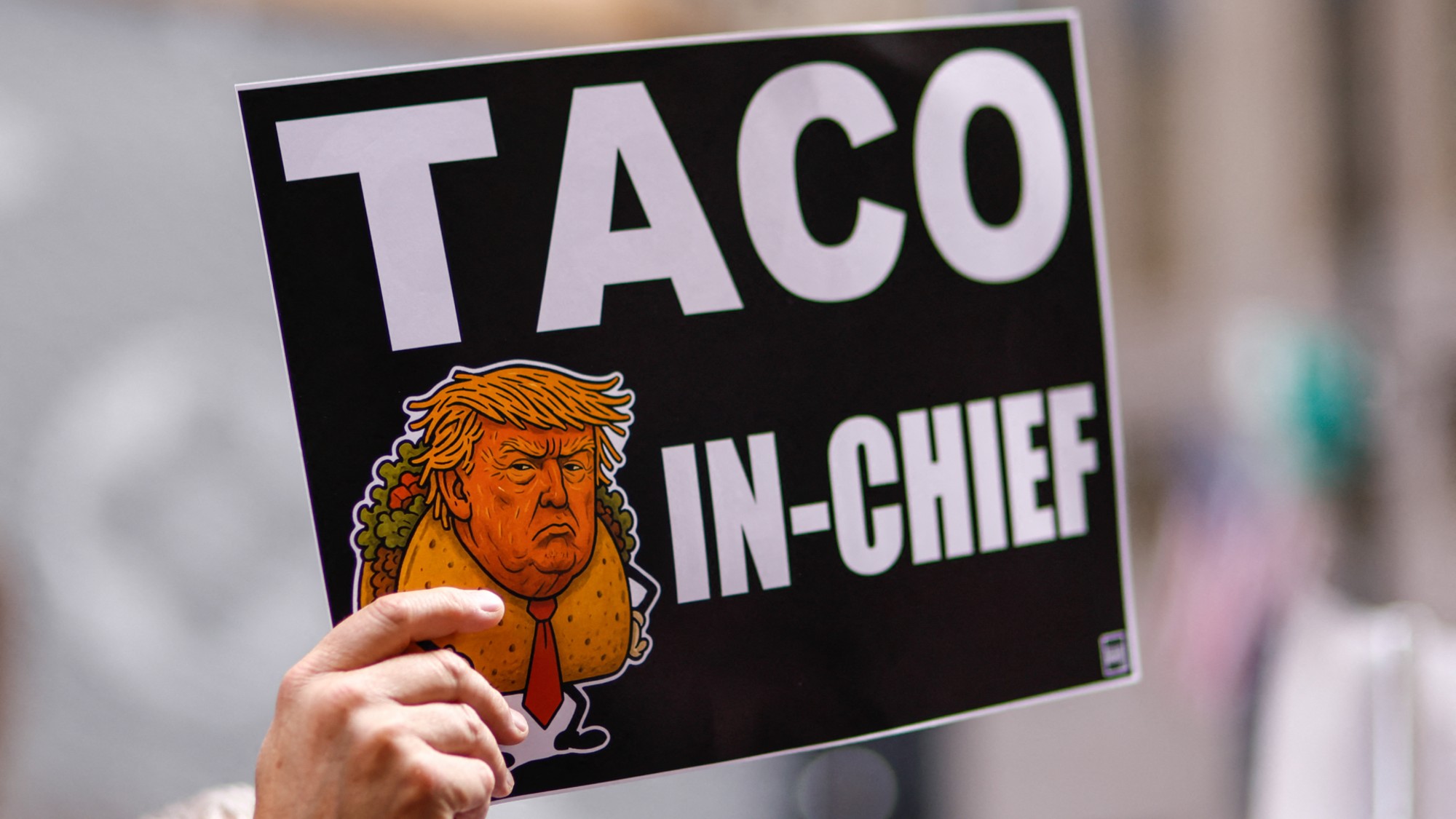 A person holds a sign with an image of Donald Trump as Taco in Chief as people demonstrate during a Labor Day "Workers over billionaires" rally outside Trump Tower in New York City on Sept. 1, 2025.