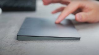 A shot of a man using the Apple Magic Trackpad on a desk