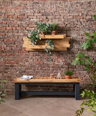 Chunky wooden shelf mounted on outdoor red brick wall