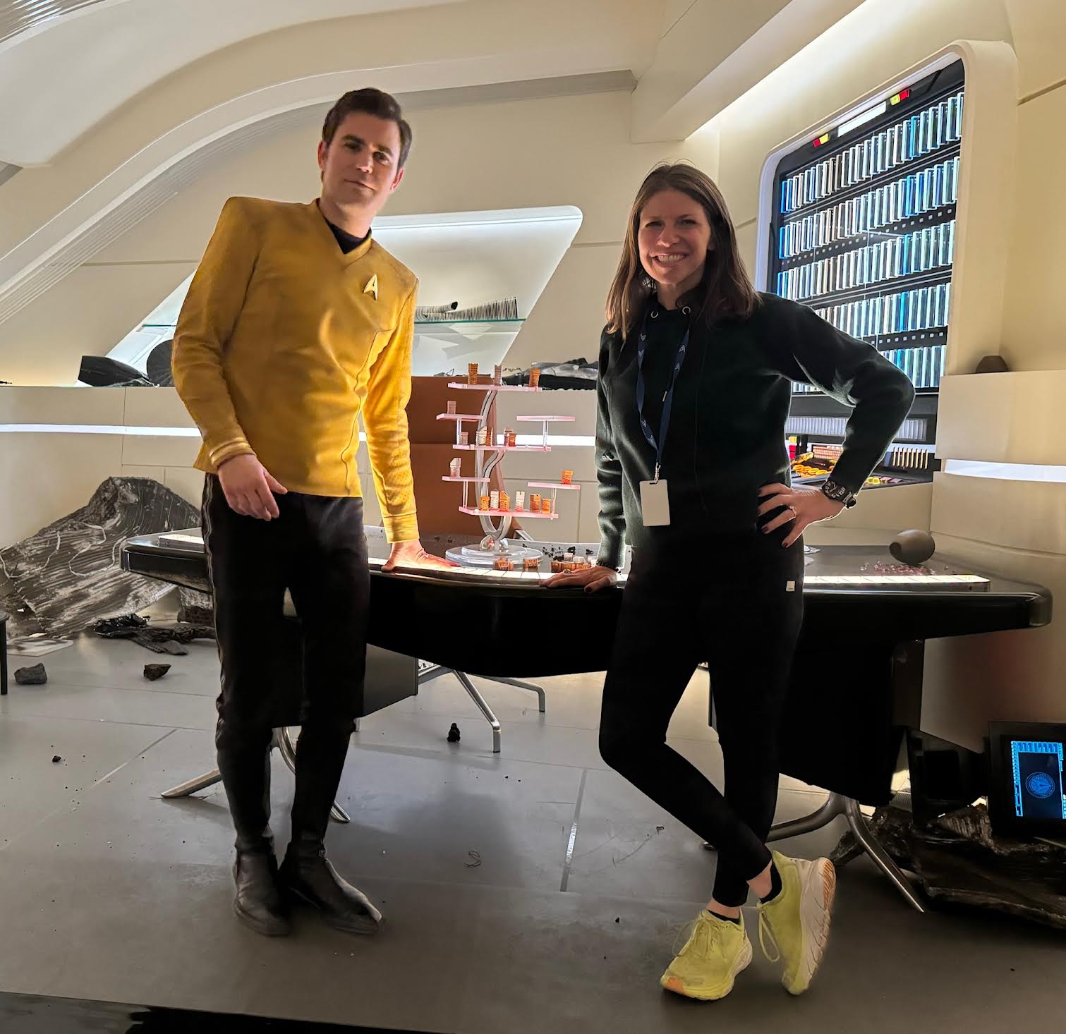 a man and a woman pose on a sci-fi tv series' starship set.