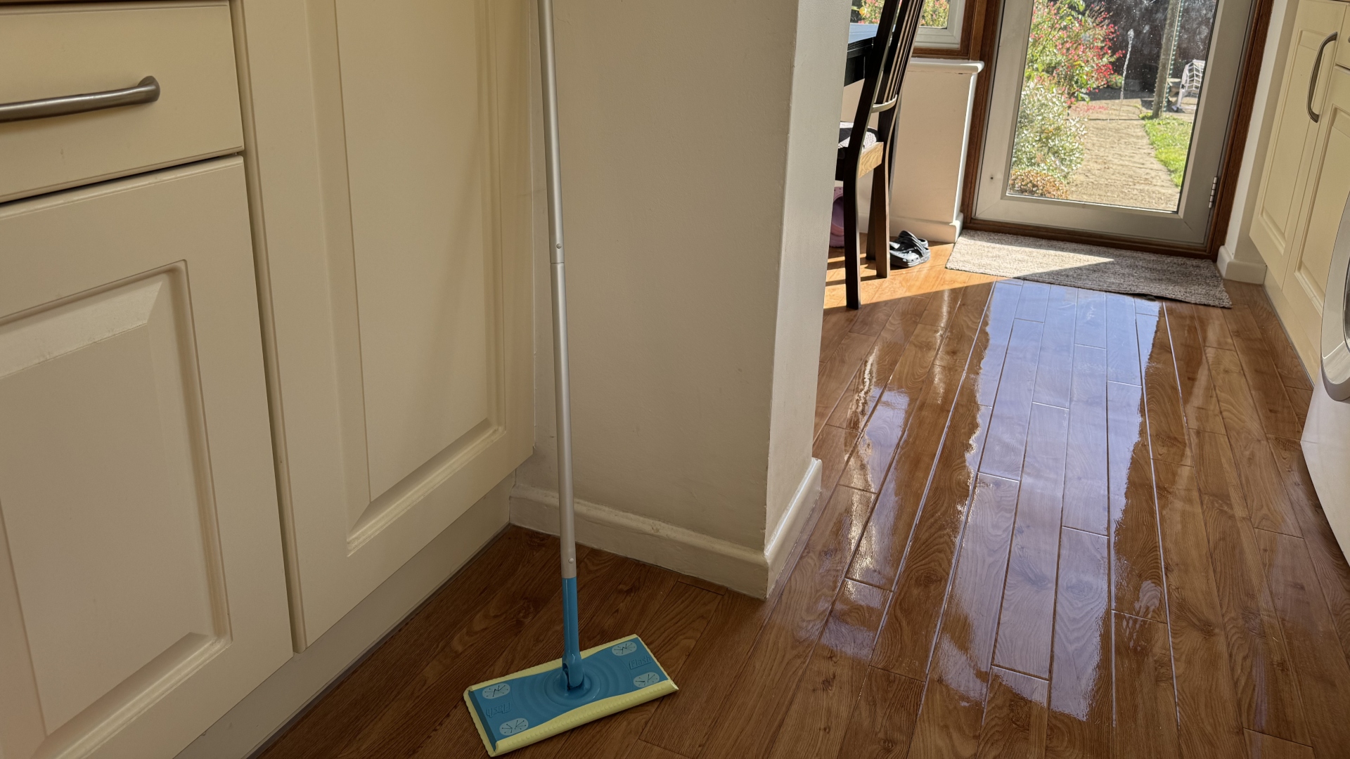 A Flash Speed Mop propped against a kitchen wall