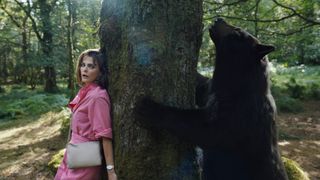 (L to R) Keri Russell as Sari, hiding from, the bear in Cocaine Bear