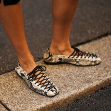 woman wearing a pair of snakeskin flats 