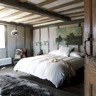 master bedroom with floorboard sheepskin rug