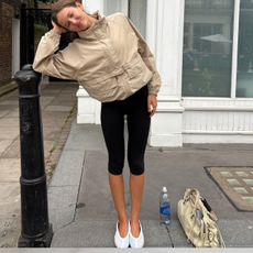 Fashion person Ruby Lynn wears a legging outfit 2025. She wears capri leggings, funnel neck beige jacket and adidas sneakerina.
