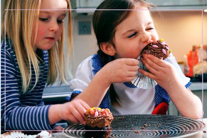 Two girls eating chocolate cupcakes