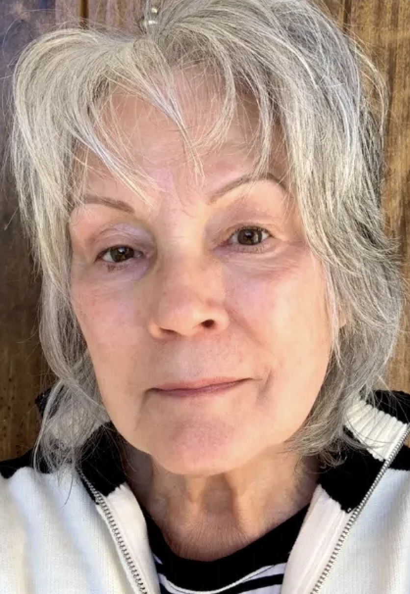A woman with gray hair and a white striped shirt before Dr. Jart+ BB Tinted Moisturizer With Niacinamide and SPF 40.