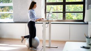 A woman stands at her desk