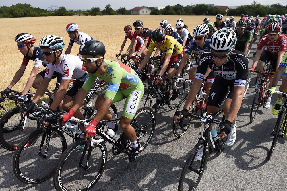 Rohan Dennis, wearing the overall leader's yellow jersey, and France's Nacer Bouhanni, wearing the best sprinter's green jersey, ride in the pack as they take the start of the 228 km fourth stage.