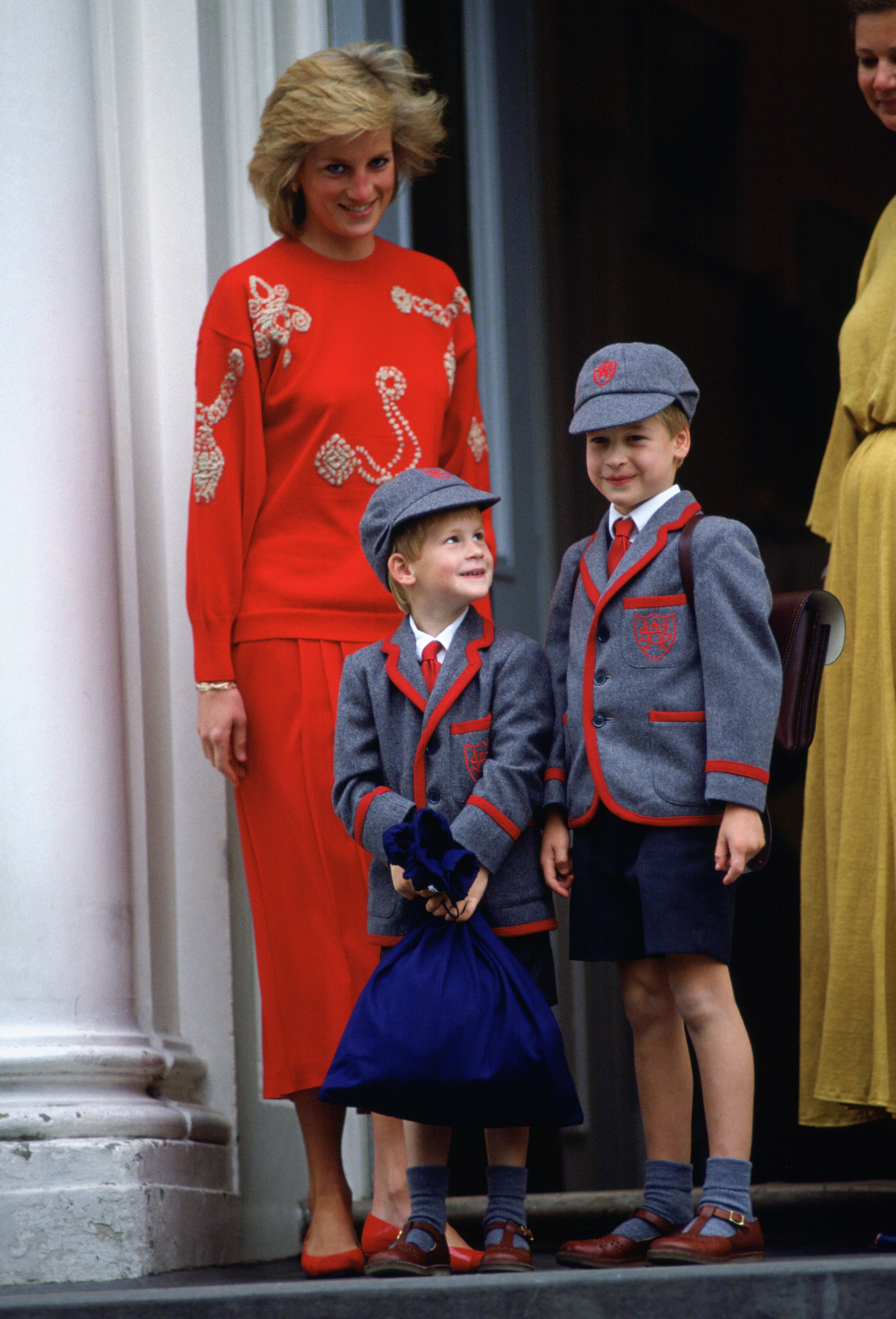 Princess Diana standing with Prince Harry and Prince William in their school uniforms