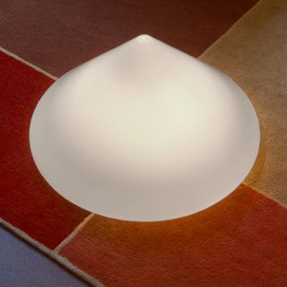 A rounded cone-like shape lamp made out of Dedar fabric.