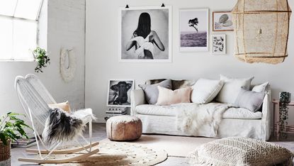 Mono boho living room scheme with tactile textures, a variety of scatter pillows, a large statement natural pendant, and a black and white gallery wall idea.