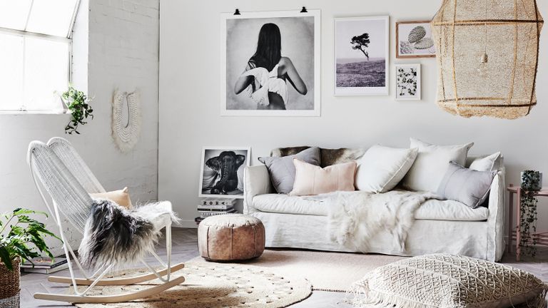 Mono boho living room scheme with tactile textures, a variety of scatter pillows, a large statement natural pendant, and a black and white gallery wall idea.