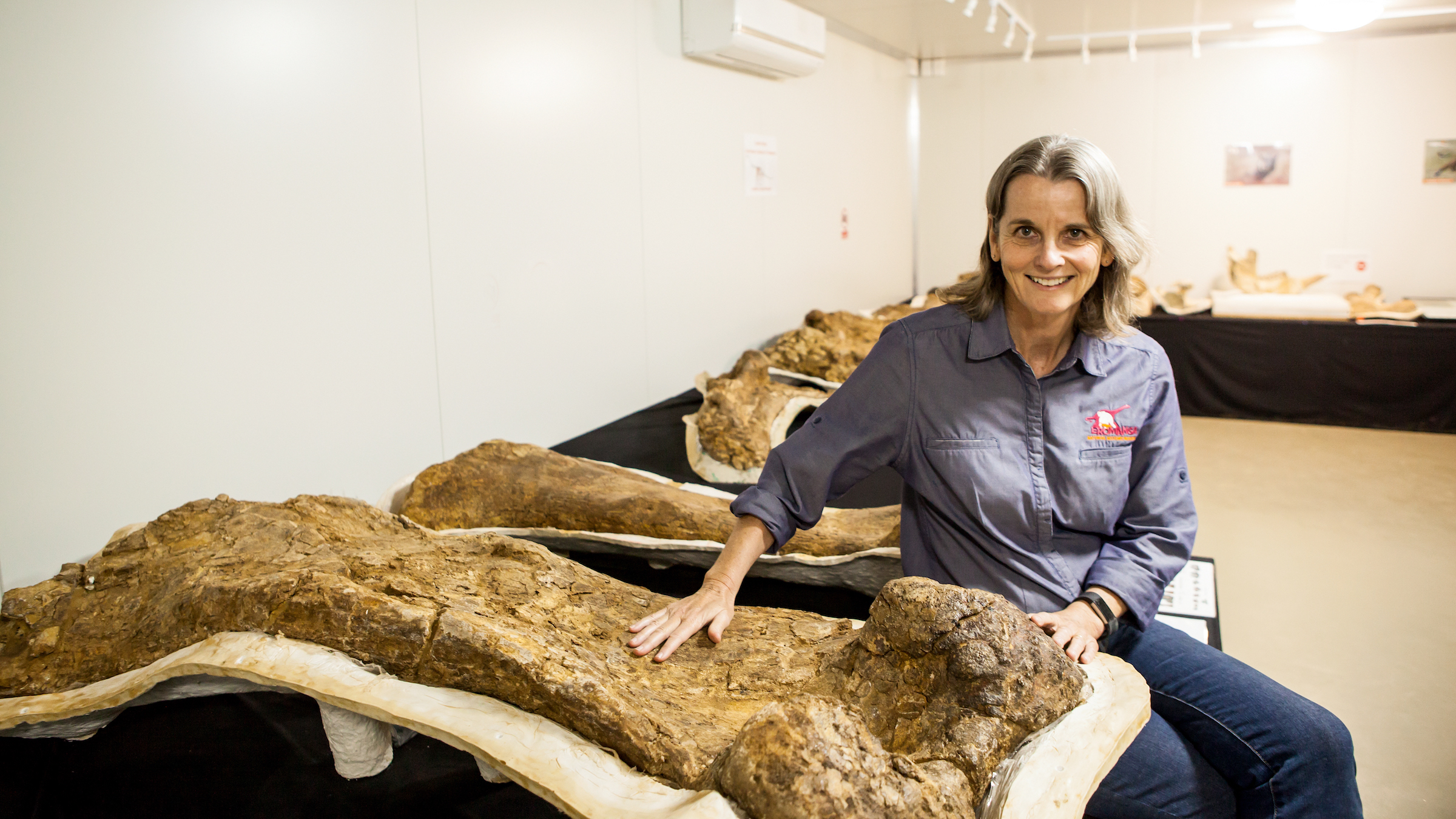 Robyn Mackenzie, Eromanga Natural History Museum director and palaeontologist, sits next to the actual fossils at the museum.