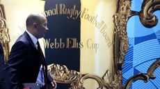 England head coach Eddie Jones walks past a picture of the Webb Ellis Cup
