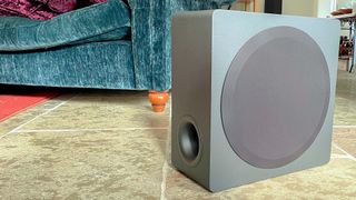 Active subwoofer from LG S95QR soundbar package on stone floor at reviewer's home