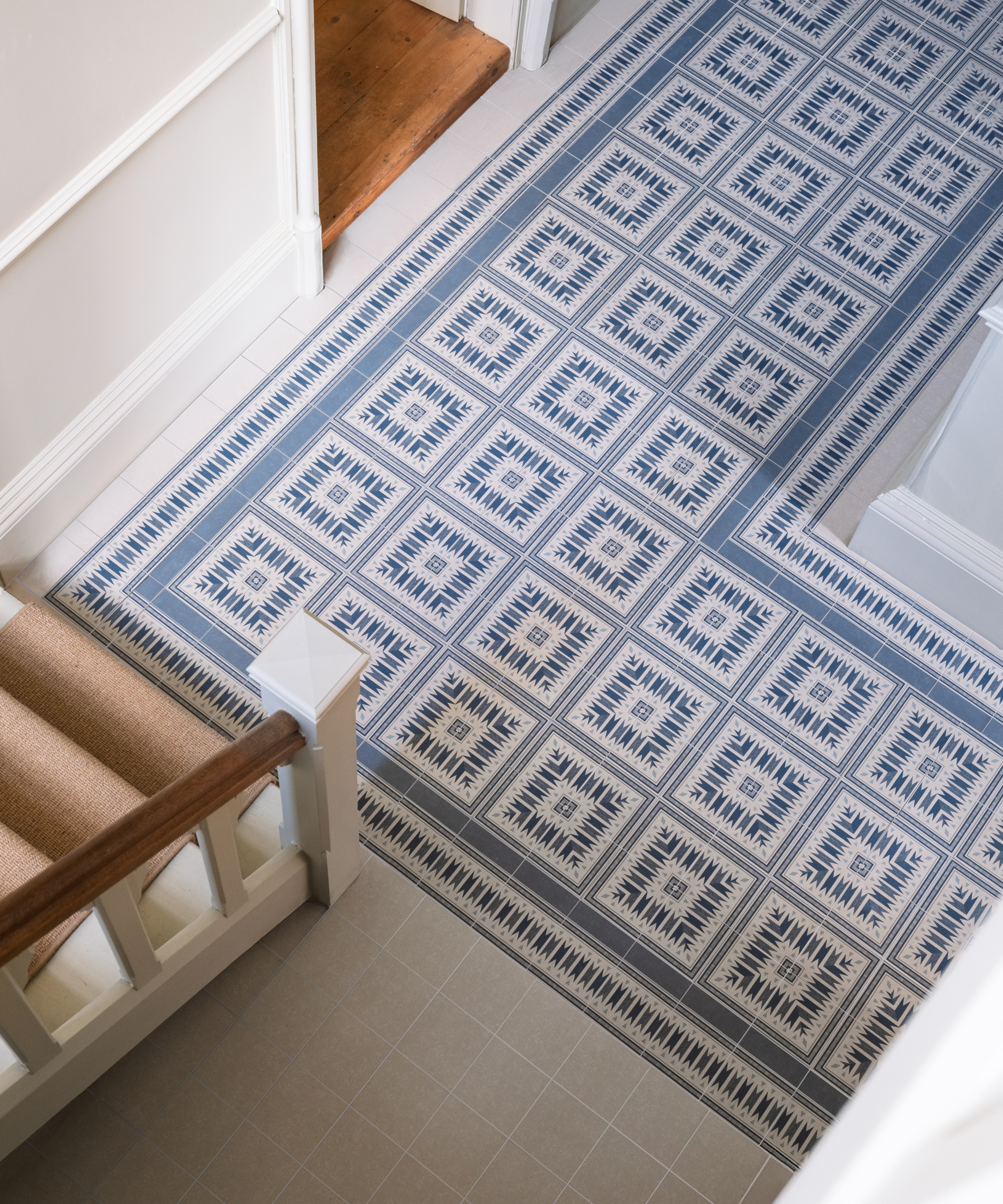 hallway with tiled runner effect flooring in front of staircase