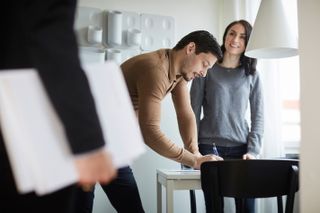 couple signing documents on the table for stamp duty