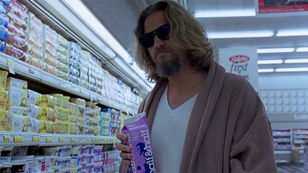 Jeff Bridges in a bathrobe, a white tee and sandals inside a grocery store in The Big Lebowski. He is also wearing sunglasses inside.